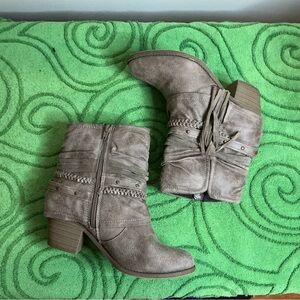 Jellypop taupe booties featuring side zippers, braided details, and fringe.